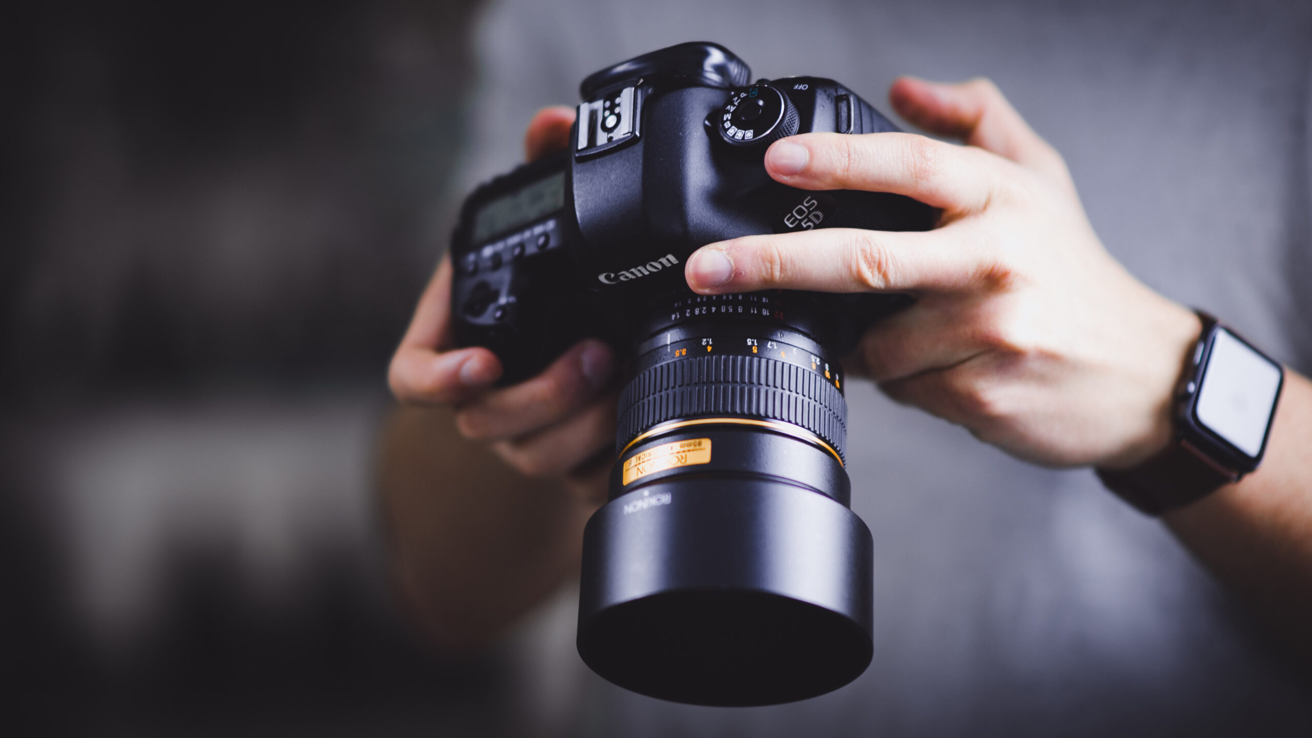Human hands holding a Canon camera