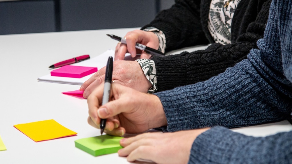 People writing on post-it notes