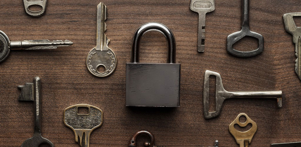 various different keys on a table surrounding a padlock