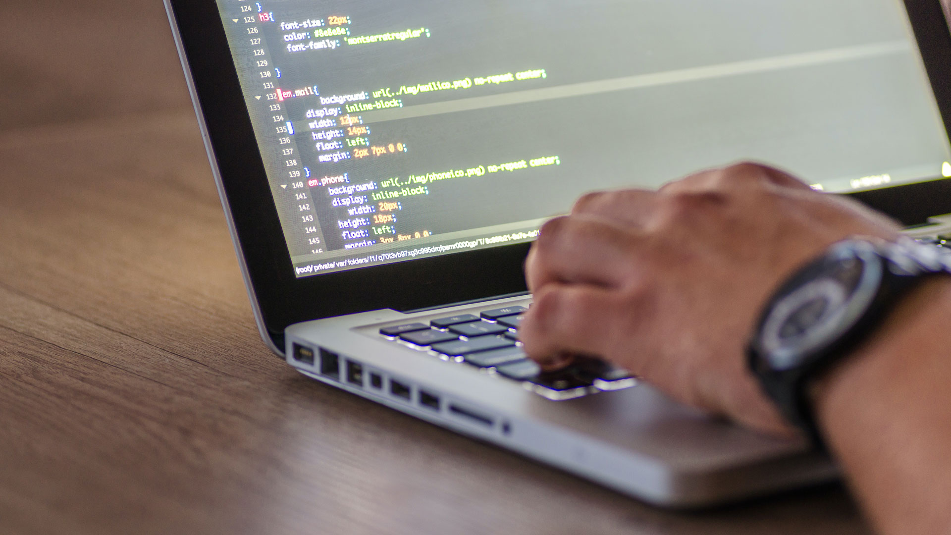 Close up of laptop screen with code, and hand of person typing