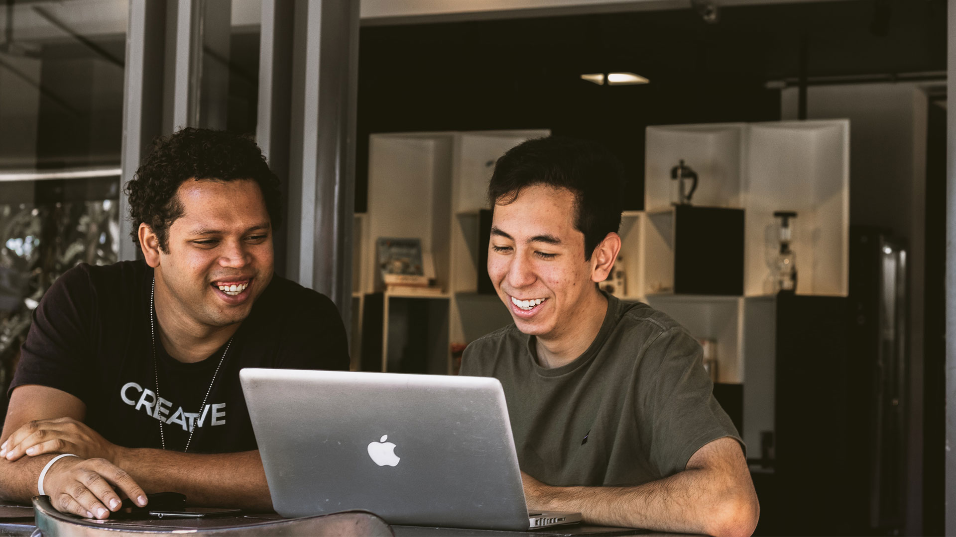 Two men working at a laptop