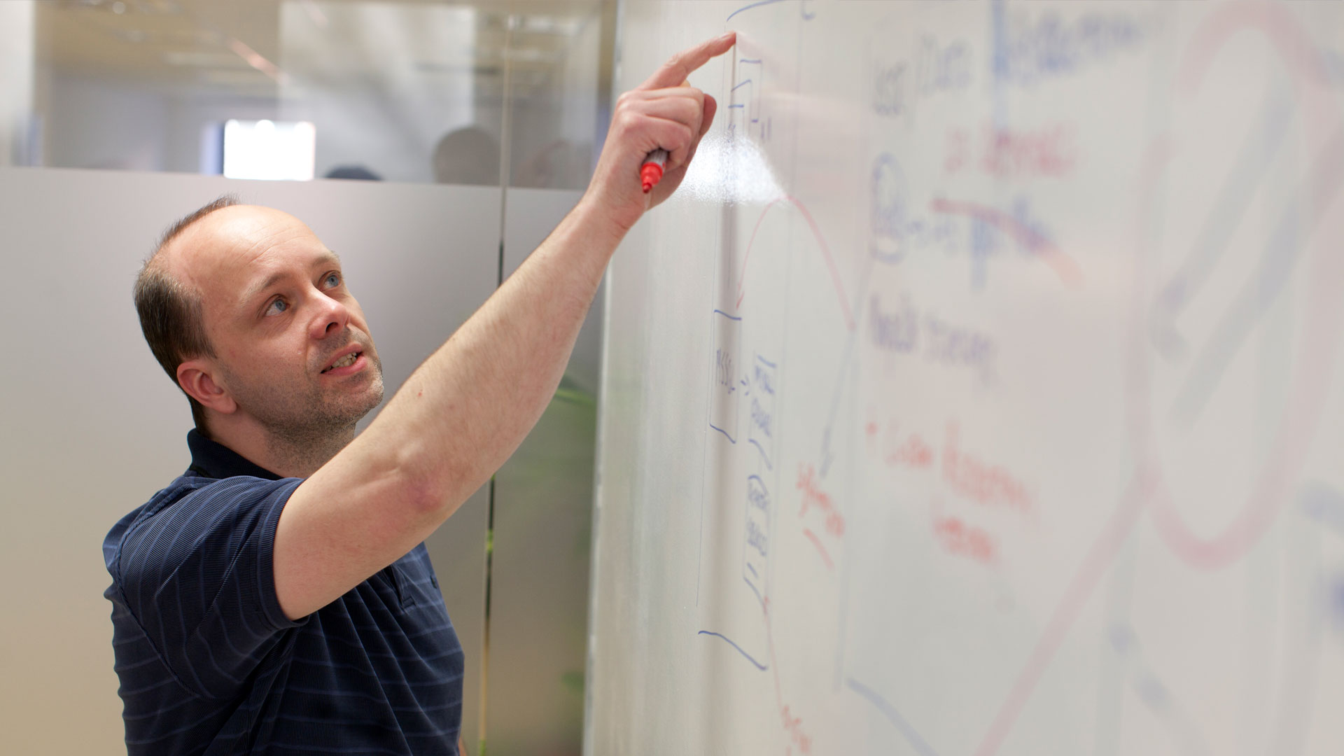 a man pointing to the data on a board