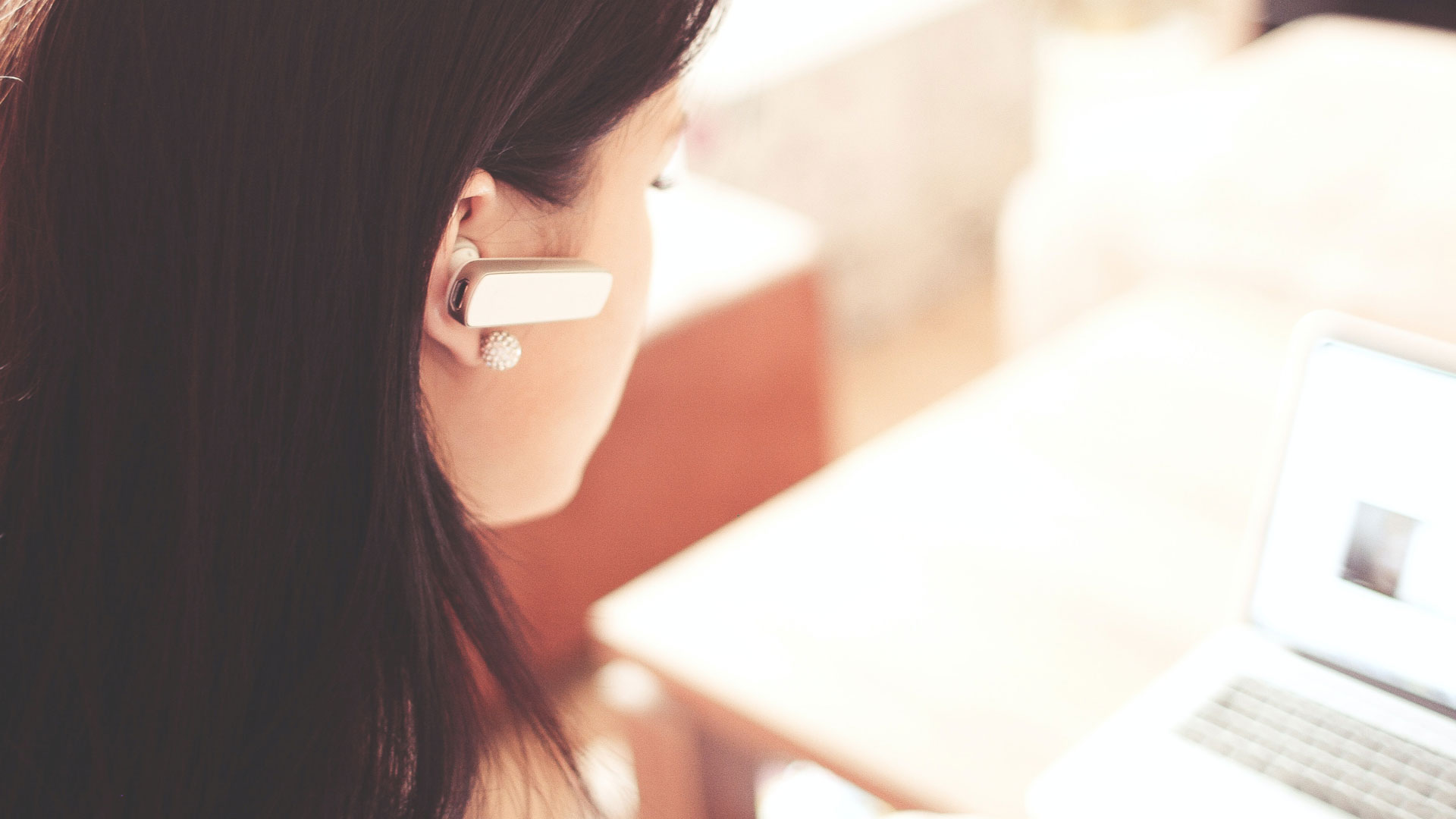 Woman with headset sat in front of laptop