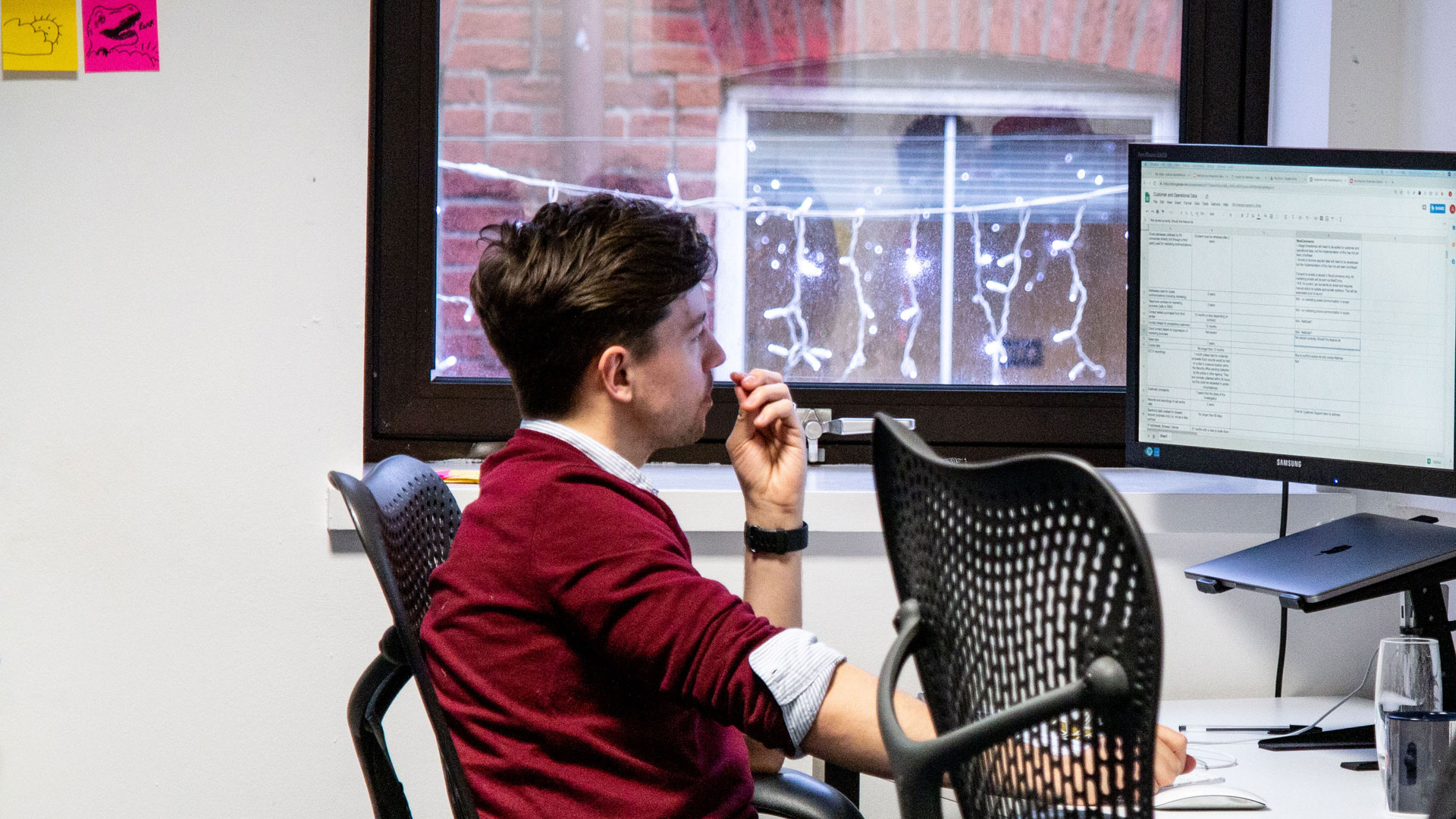 Person in an office setting, sat in front of computer monitor