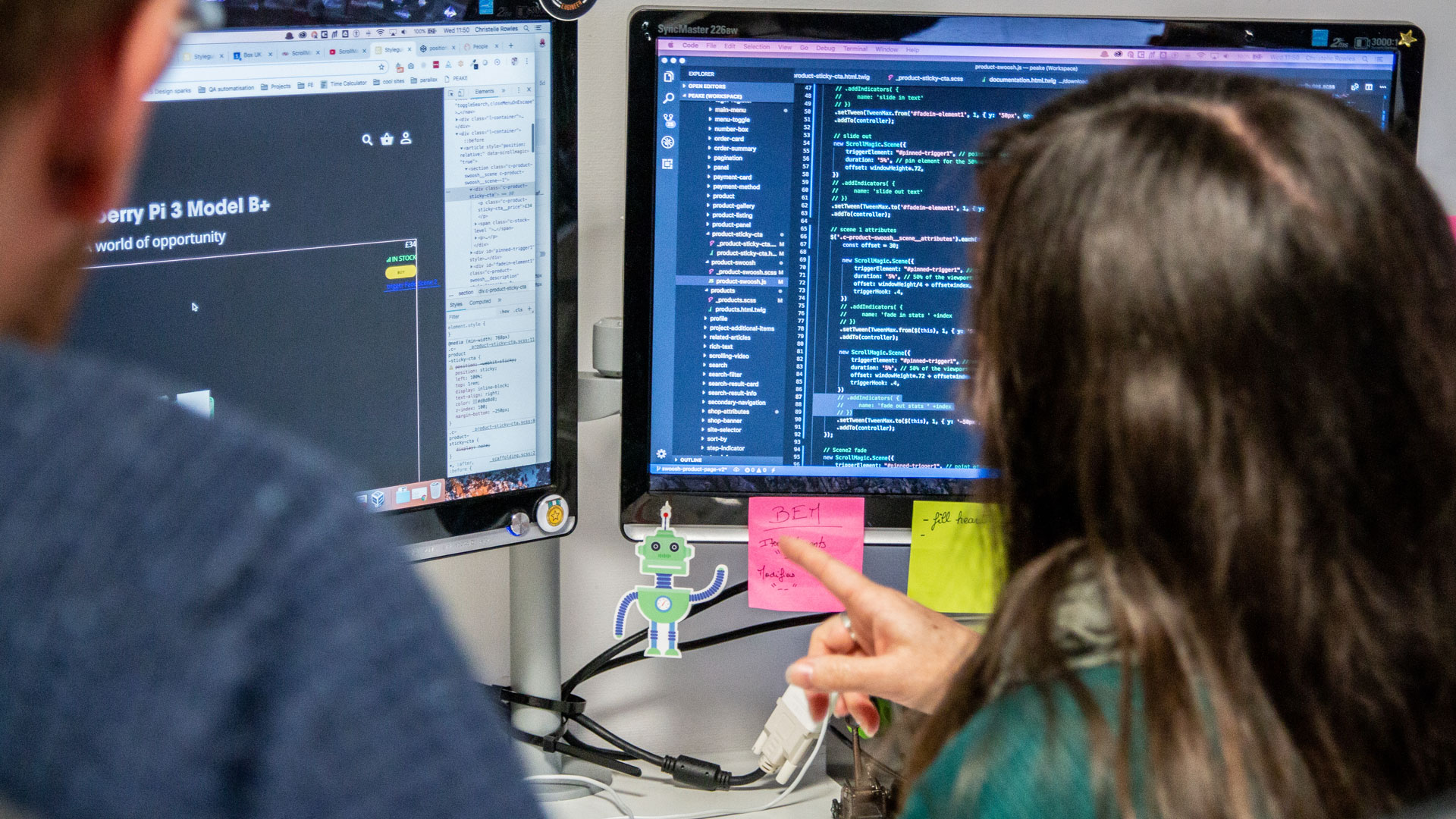 Two people looking at a screen with code on it