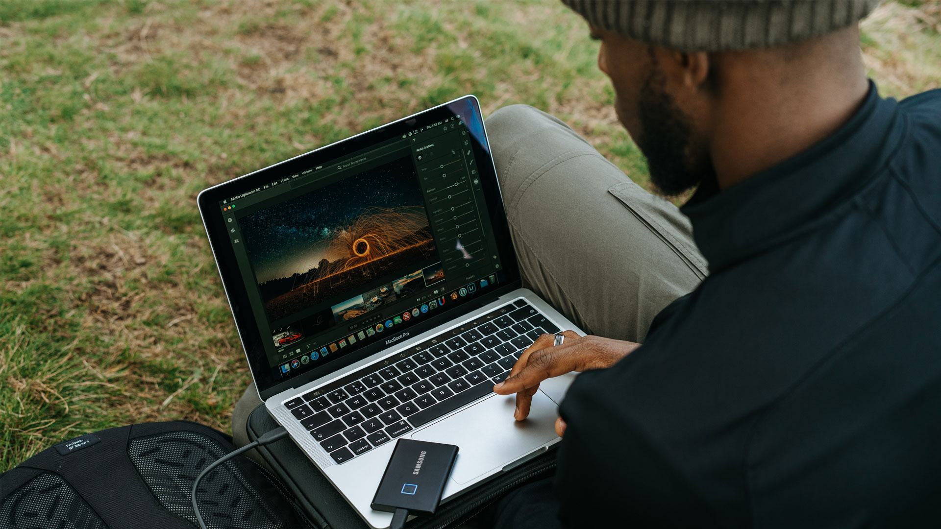 Person using a laptop to edit photos, outdoors