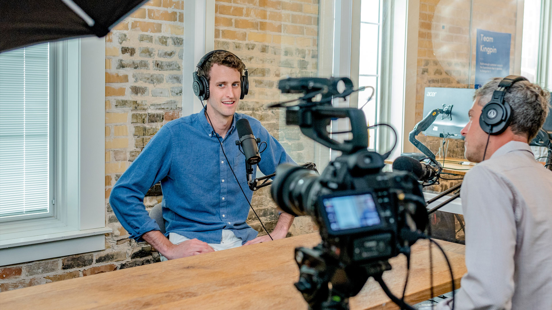 Man in front of camera with microphone and headphones