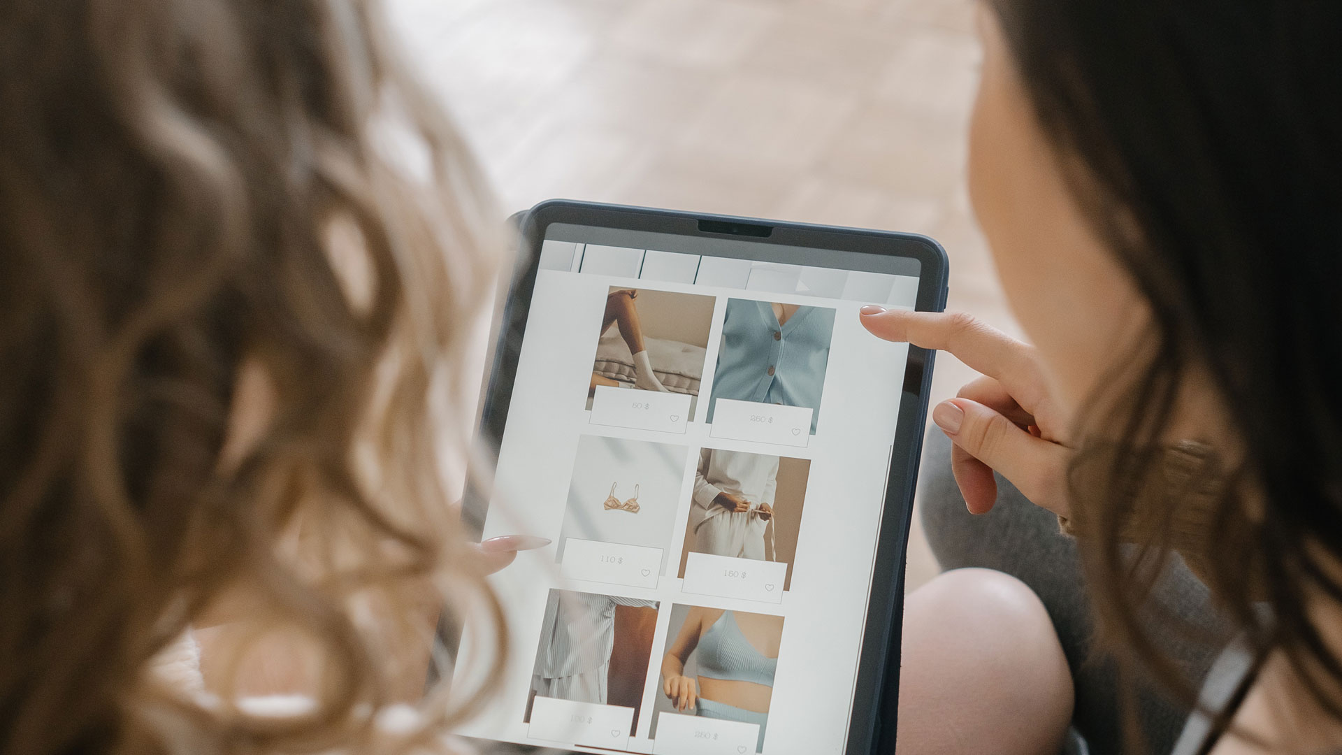 Two people viewing an online shop on a tablet device