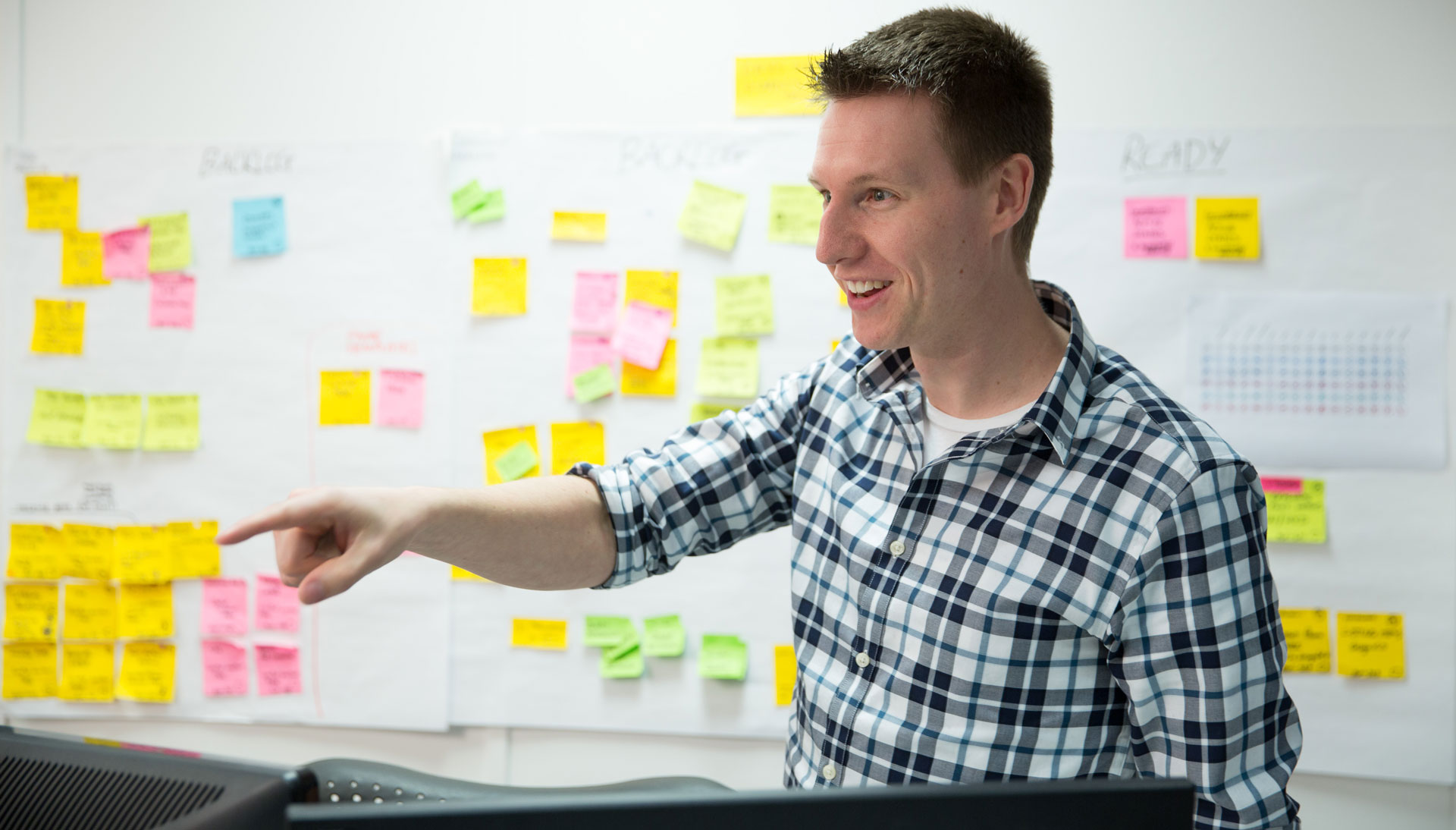 Consultant pointing with post-it notes mapped in background