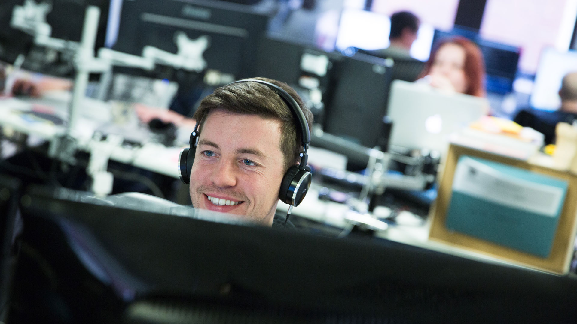 Person working in front of screen with headphones