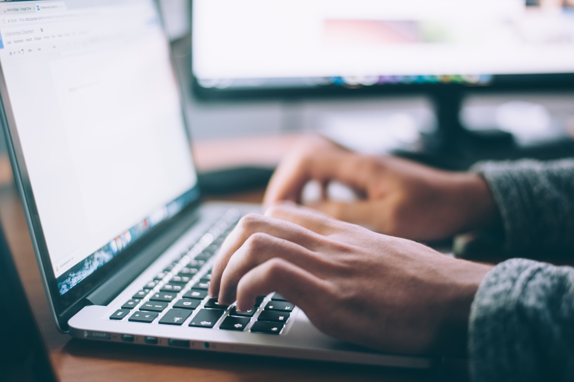 Close up of person's hands typing on laptop