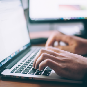 Close up of person's hands typing on laptop