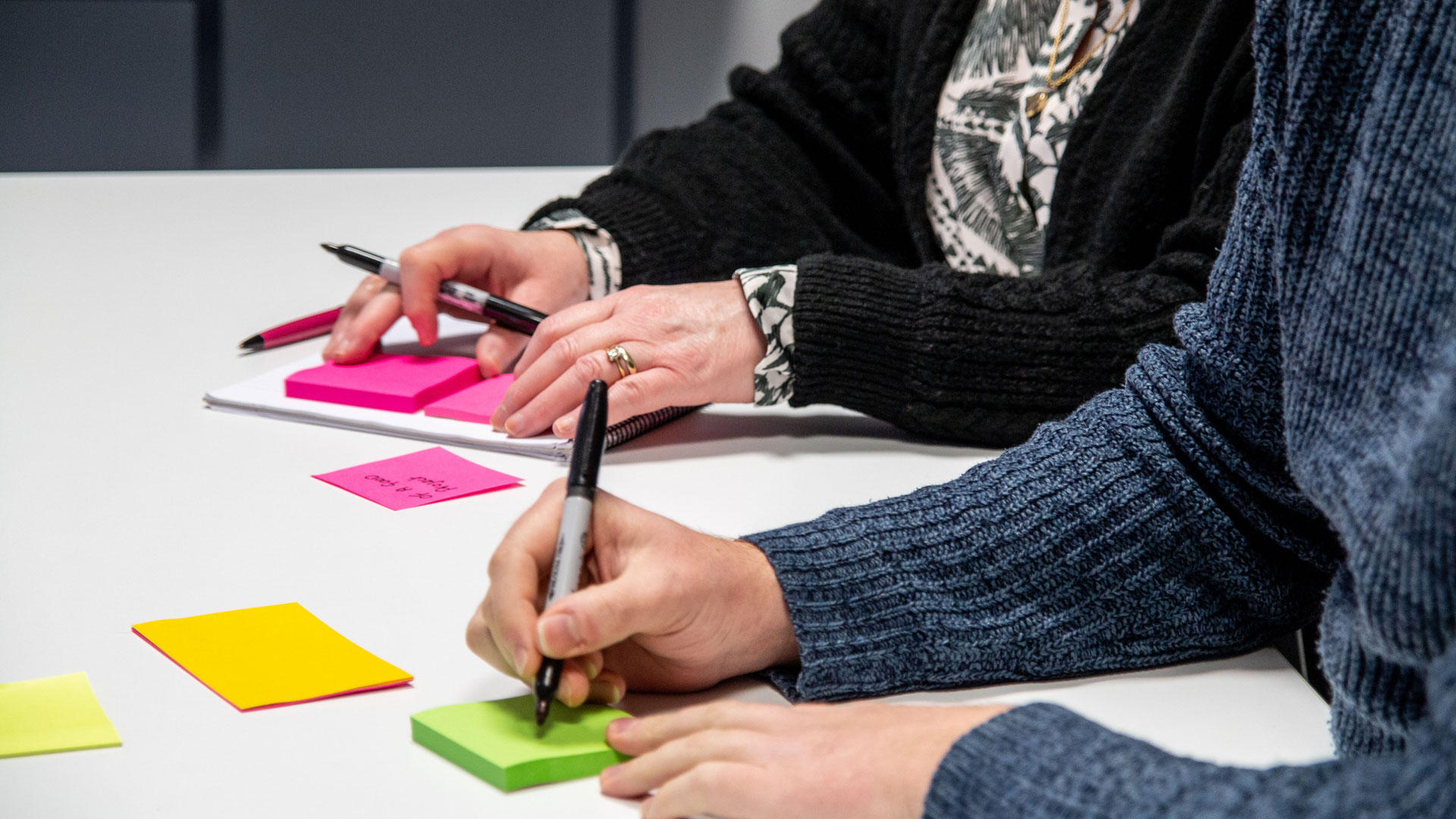 Abstract shot of people writing on post-it notes