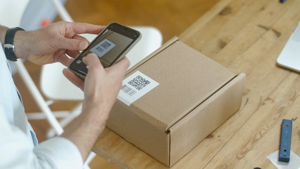 Person using smartphone to scan QR code on packaging